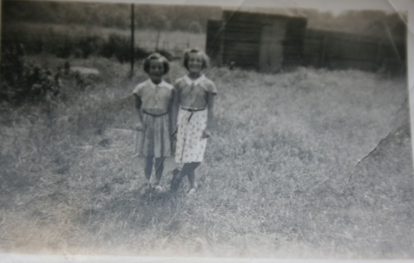 Penny and Margaret in the back garden of No1, garden shed and cowslip field in the background.